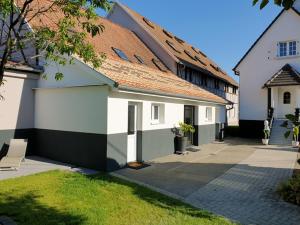 un patio de una casa con paredes blancas y verdes en Chez Stef en Marckolsheim