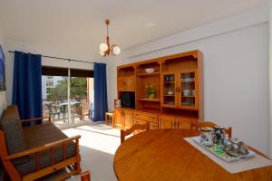 a kitchen with a wooden table and a dining room at Casa Fragata B in Armação de Pêra