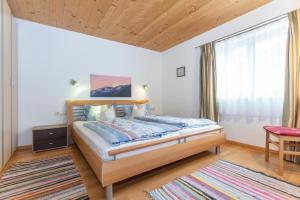 a bedroom with a bed and a table and a window at Haus Machreich in Maria Alm am Steinernen Meer