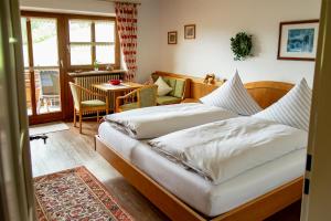 een slaapkamer met 2 bedden en een tafel en een stoel bij Gästehaus Sonnenberg in Bolsterlang