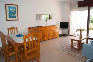 ein Wohnzimmer mit einem Esstisch und einem TV in der Unterkunft Mediterranea in La Pineda