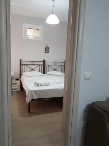 een slaapkamer met een bed met witte lakens bij Villasabella 2 Apartments in Zakynthos