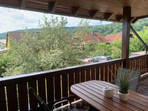 einen Holztisch auf einem Balkon mit Aussicht in der Unterkunft Ferienwohnung Apfelblüte in Burgbernheim