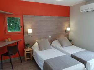 2 Betten in einem Hotelzimmer mit roten Wänden in der Unterkunft Domaine du Surgié in Figeac