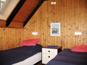 een slaapkamer met 2 bedden en houten lambrisering bij Chalet Lofsdalen Fjällbjörken - HJD054 by Interhome in Lofsdalen