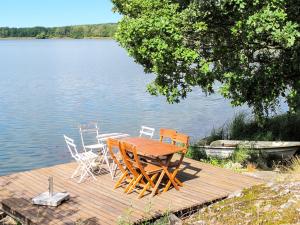 格內斯塔的住宿－Chalet Ilandet - SDM530 by Interhome，湖上码头上的木桌和椅子