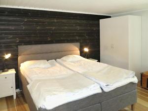 a bedroom with a large bed with a wooden wall at Chalet Kvisthån Idegranen - HJD059 by Interhome in Vemhån