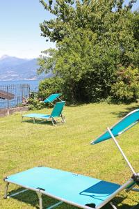 dos sillas y una mesa de ping pong en el césped en Hotel Helvetia en Lezzeno