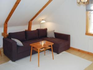 a living room with a couch and a table at Chalet Bäcklunda - NAK170 by Interhome in Mullhyttan