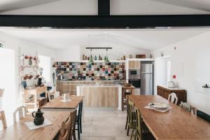 a kitchen and dining room with wooden tables and chairs at Casa dos Junqueiros - Countryside Guest House in Caldas da Rainha