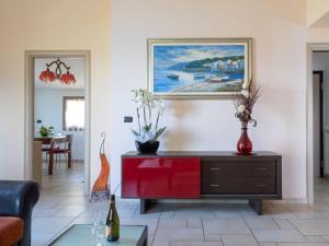 ヴェンティミリアにあるApartment Villa Ginestra by Interhomeのリビングルーム(赤いドレッサー、壁画付)