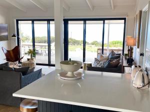 a kitchen and living room with a table and chairs at The Cape in Emu Bay