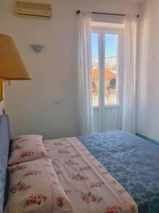 sypialnia z łóżkiem i oknem w obiekcie Residenza Celeste al 28 w mieście Ischia