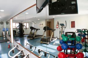 a gym with several tread machines and a mirror at Hotel Nacional Inn São José dos Campos in São José dos Campos