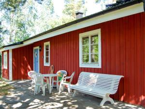 czerwony dom ze stołem, krzesłami i ławką w obiekcie Chalet Harge Sörgård - NAK 043 by Interhome w mieście Hammar