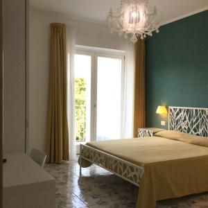 ein Schlafzimmer mit einem Bett und einem großen Fenster in der Unterkunft A casa di Silvia in Scario