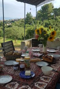 una mesa con comida y un jarrón de girasoles en Mas du Kairos en Venasque