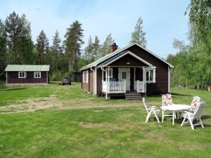 a small cabin with a table and chairs in the yard at Chalet Ramsjö - HSL020 by Interhome in Ramsjö