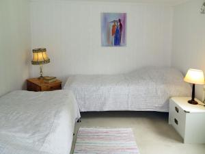 a bedroom with two beds and a lamp on a table at Chalet Ramsjö by Interhome in Ramsjö +9 photos