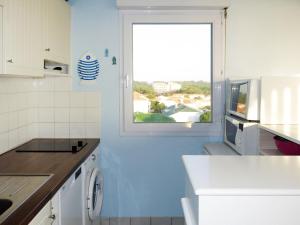 cocina azul y blanco con ventana en Apartment Pamplemousse Face Mer by Interhome, en Les Bains