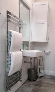 ein Badezimmer mit einem Waschbecken, einem Spiegel und Handtüchern in der Unterkunft The Old Bakery - 11A in Berkeley