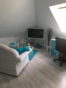 un soggiorno con divano bianco e TV di Mischa a Heide