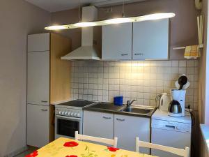 a small kitchen with a sink and a table with a table at Ferienwohnung Seeadler in Freest