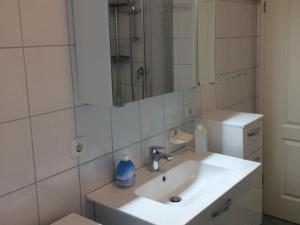 a white bathroom with a sink and a mirror at Ferienwohnung Seeadler in Freest