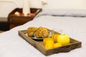 - un plateau de viennoiseries et de fruits sur un lit dans l'établissement Resina Guest House, à Ercolano