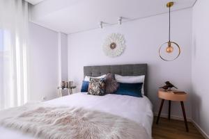 a bedroom with a white bed with a furry blanket at Kerala 49, Deluxe Flat in Historic Center in Peniche
