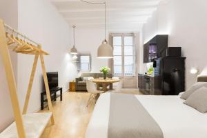 a bedroom and living room with a bed and a table at Ola Living CND Canuda in Barcelona