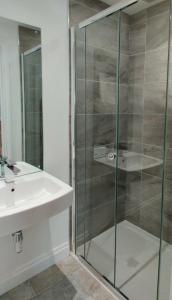 a bathroom with a glass shower and a sink at The Old Bakery - 11A in Berkeley