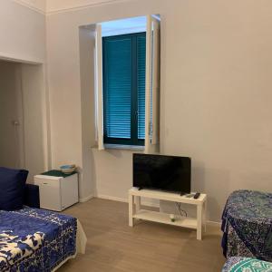 Habitación con cama, TV y ventana. en Molo35, en Isquia
