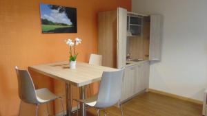 a kitchen with a table with chairs and a sink at Turin Airport Hotel & Residence in San Francesco al Campo