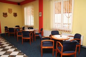 a dining room with tables and chairs and a checkered floor at Milotín in Zuberec