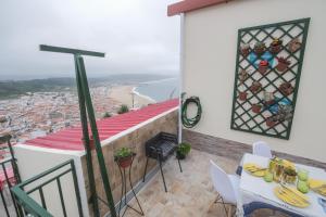 een balkon met een tafel en stoelen en uitzicht bij Casa Ganga in Nazaré