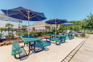 a row of picnic tables with blue umbrellas at Willow Bend in North Myrtle Beach