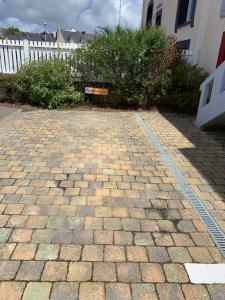 a brick driveway with a white fence in a yard at Appartement Fontaine Morgat in Crozon