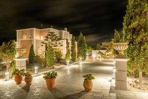 a large white building with potted plants in front of it at Villa Leon in Vourvoúlos