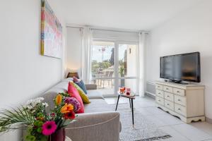 a living room with a couch and a tv at Residence Pure in La Ciotat