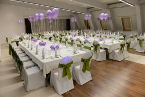 a banquet hall with white tables and chairs with purple bows at Hotel Royal Spa in Banja Koviljača +37 photos