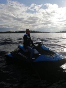 a man sitting on a jet ski in the water at Rämäkkä Holidays in Rautalampi