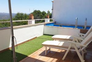 een balkon met een stoel en een zwembad bij Arriba y abajo in Zufre