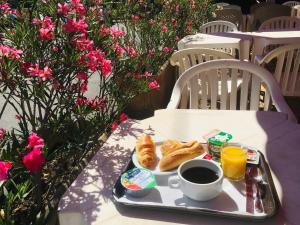 bandeja de comida para el desayuno en una mesa con café y cruasanes en Hotel Bel Alp Manosque en Manosque