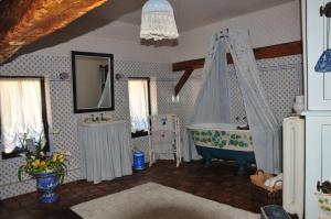 a bathroom with a tub and a sink and a mirror at LES GUENINS in Gien