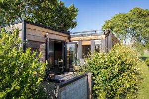 a tiny house with a porch in a garden at De Meisjes in Middelburg