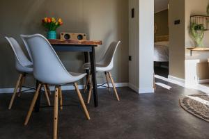a table with four chairs in a room with a bed at De Meisjes in Middelburg +17 photos