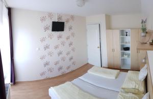 ギェネシュディアーシュにあるSzalóky Apartmanházのベッドルーム1室(ベッド2台、壁にテレビ付)