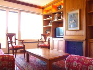 ein Wohnzimmer mit einem Tisch und Stühlen in der Unterkunft Central & Spacious | Ambassadeurs A in Crans-Montana
