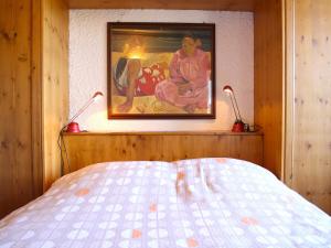 ein Schlafzimmer mit einem Gemälde an der Wand und zwei Lampen in der Unterkunft Central & Spacious | Ambassadeurs A in Crans-Montana